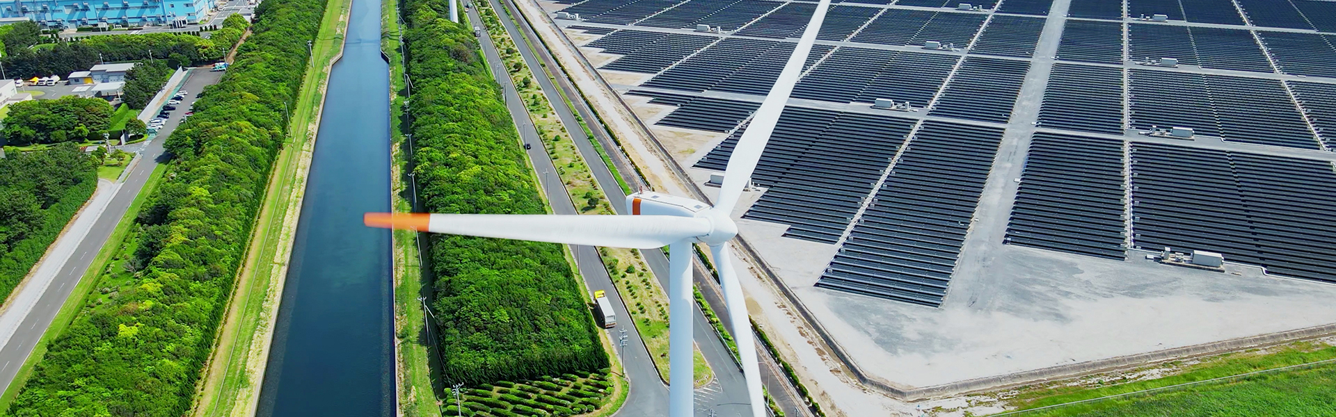 Wind turbines with solar panels in the background